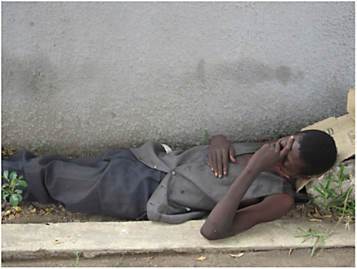 man sleeping near rock